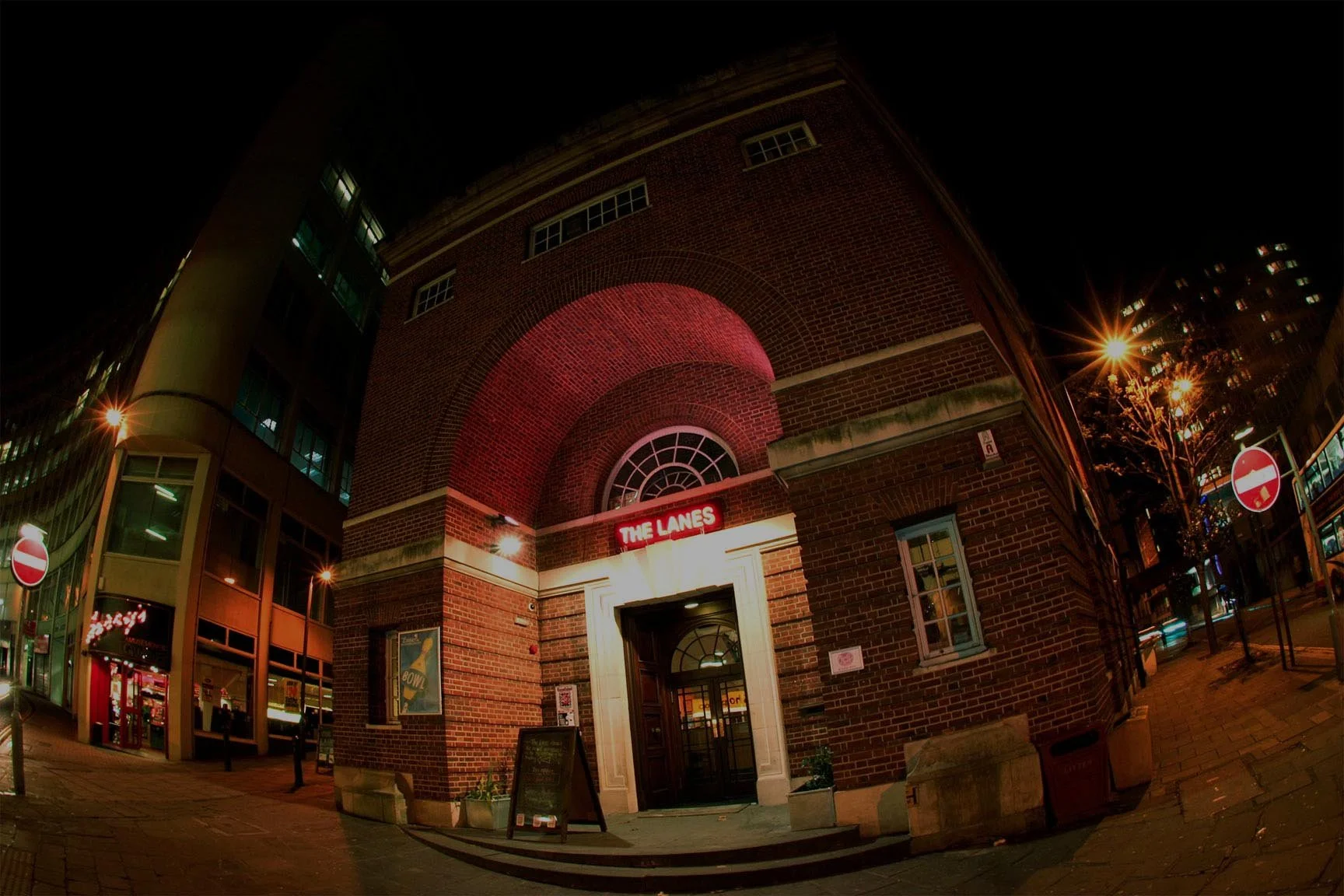 The red-brick corner of Nelson Street at night, neon glowing